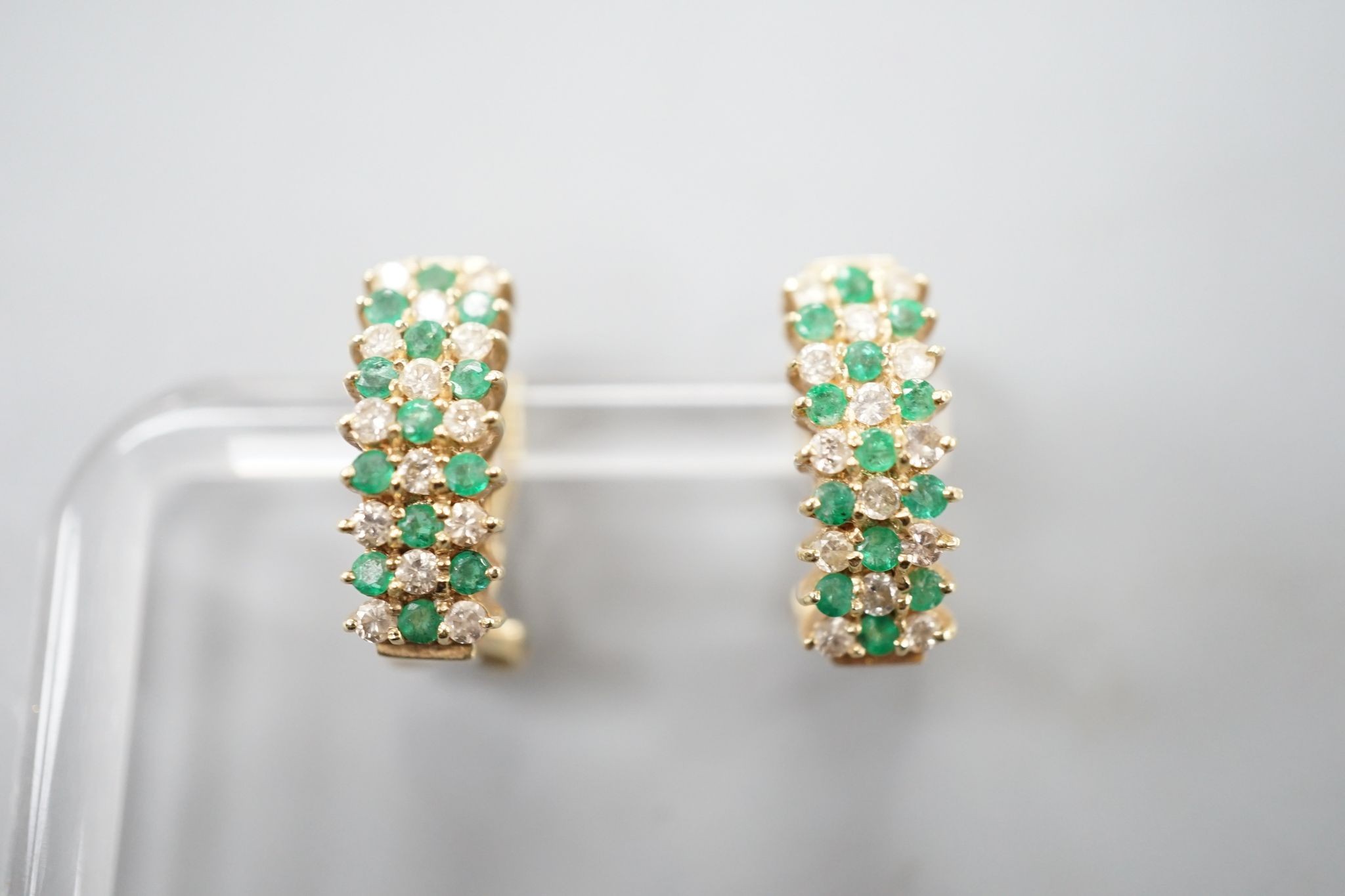 A pair of 14k yellow metal, emerald and diamond set curved earrings, 19mm, gross weight 7.4 grams.